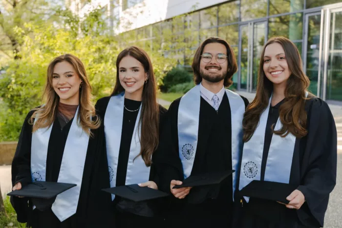 Quatre jeunes dipl&ocirc;m&eacute;s en toge, souriant apr&egrave;s leur parcours au CEFAM, &eacute;cole de management &agrave; Lyon. 